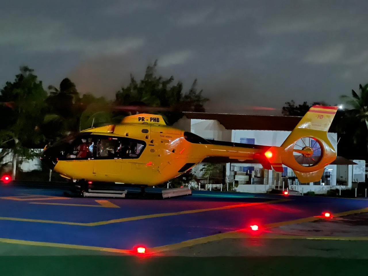 Helibarra EC-135 helicopter on illuminated helipad at night